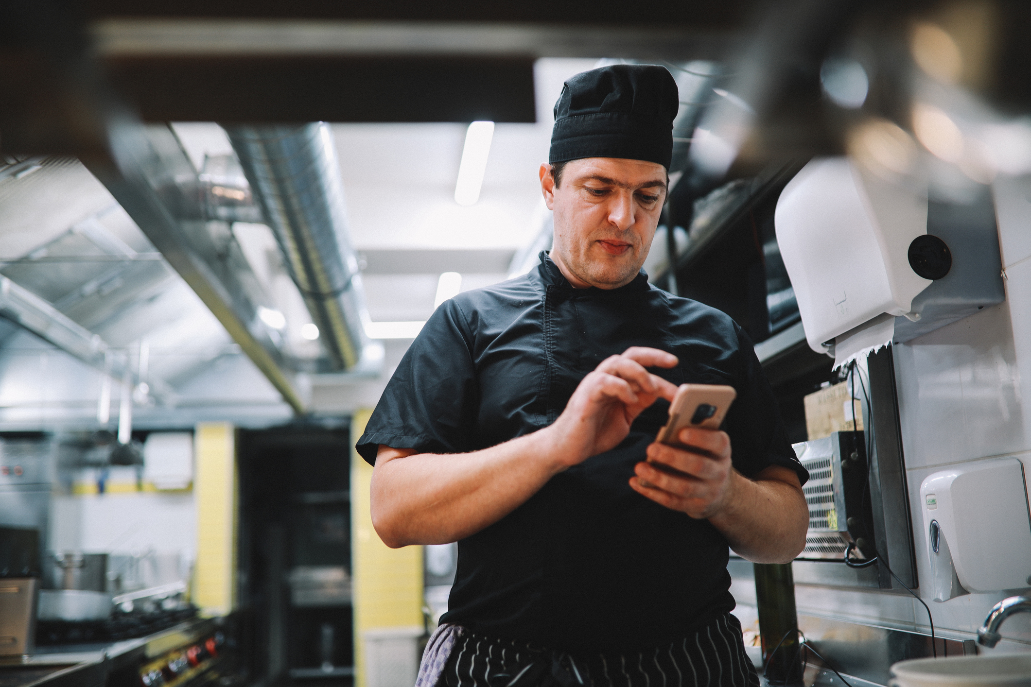 Koch mit Smartphone in der Küche